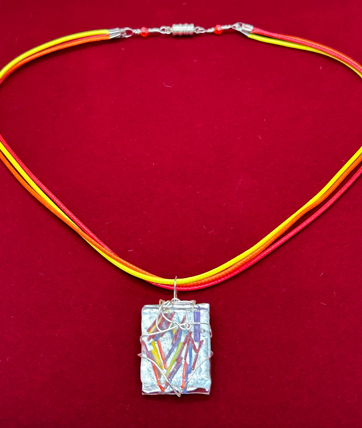 Full triple cord necklace on red background