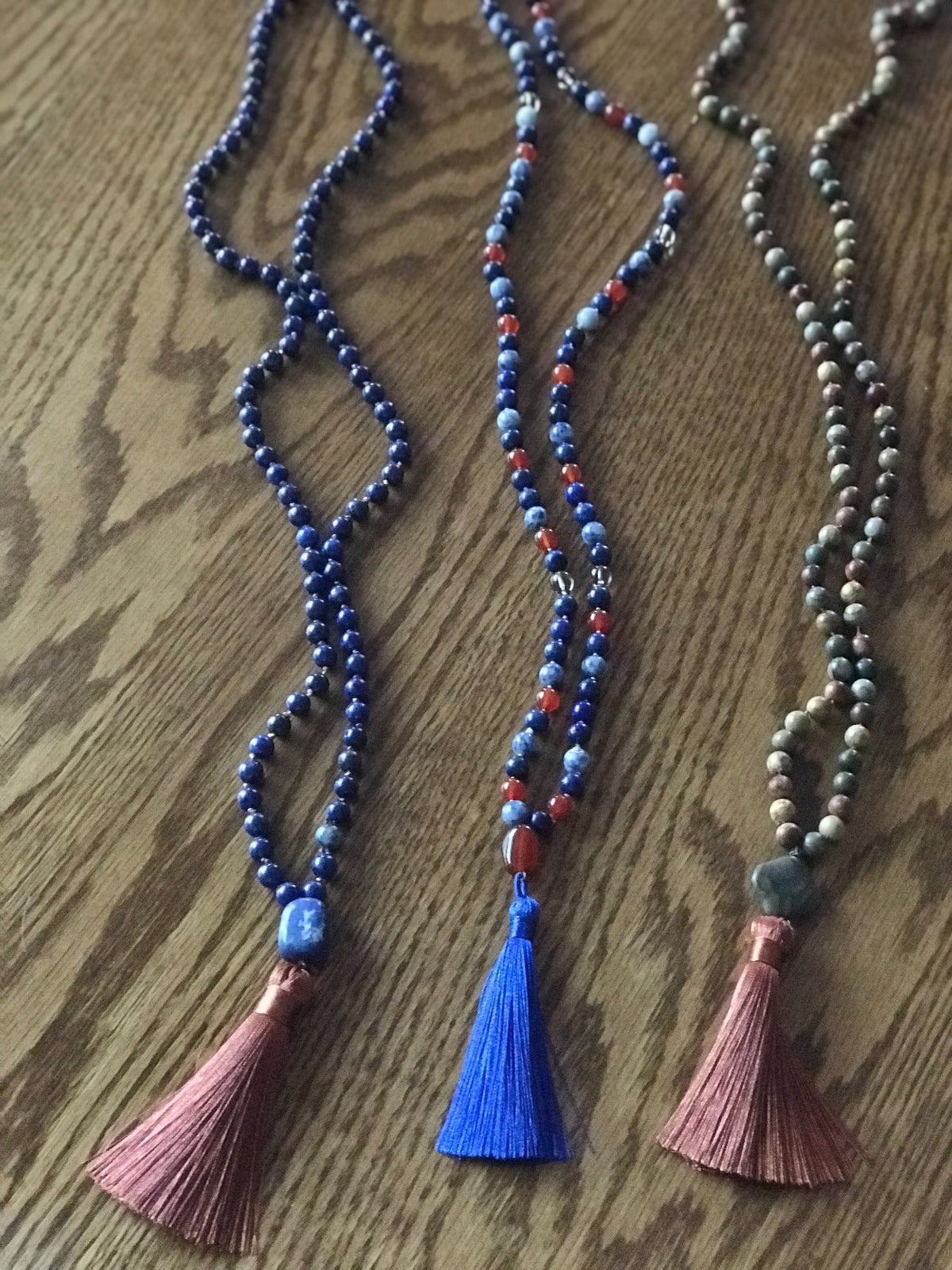 Example malas in lapis and red stones with copper and blue tassels