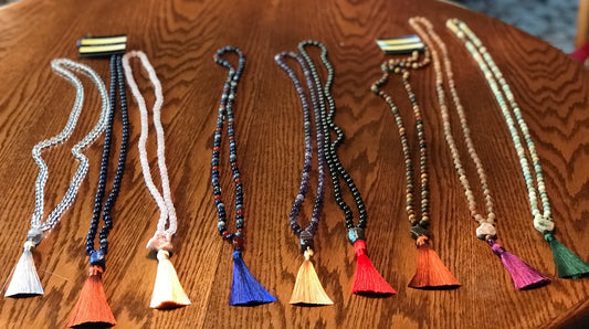 Nine handmade mala necklaces with colorful silky tassels, tightly cropped original photograph