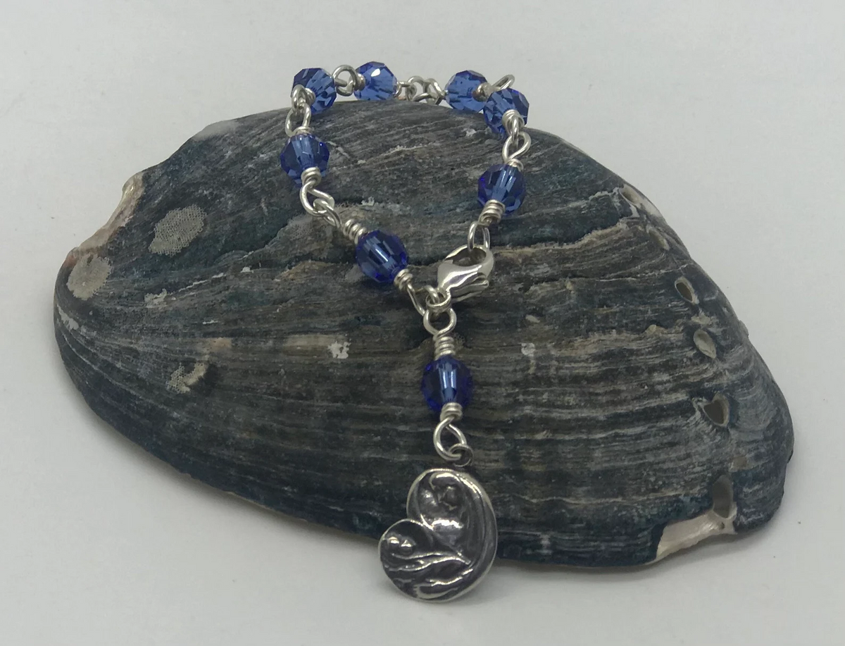 Sapphire blue crystal one-decade rosary bracelet with Madonna charm on dark stone
